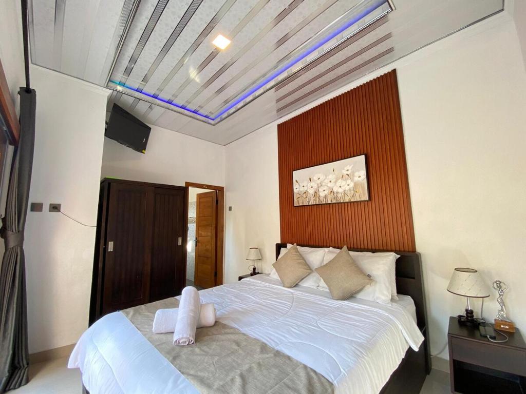 - une chambre avec un grand lit et une serviette dans l'établissement Villa Lestari by MentariPro Bali, à Lovina