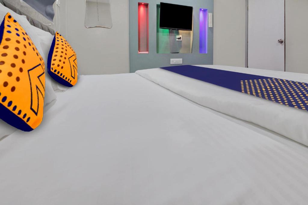 a bedroom with orange and blue pillows on a bed at Hotel O The VNP Inn in Sakardarā