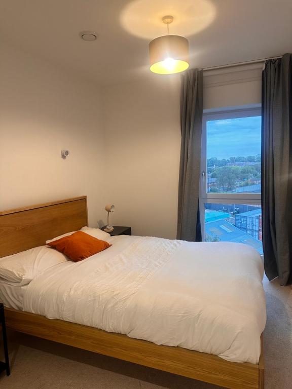 a bedroom with a bed and a large window at Cozy one Bedroom with Views In Birmingham City Center in Birmingham
