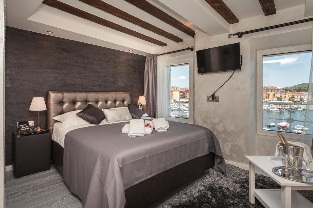 a bedroom with a large bed with towels on it at Royal Apartments in Rovinj