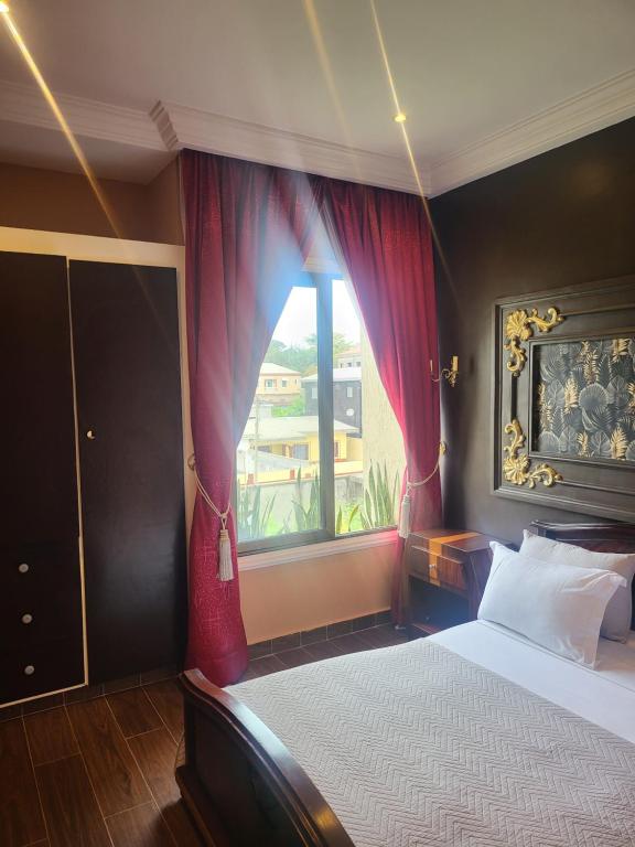 ein Schlafzimmer mit einem großen Bett und einem Fenster in der Unterkunft Justin in Pointe-Noire