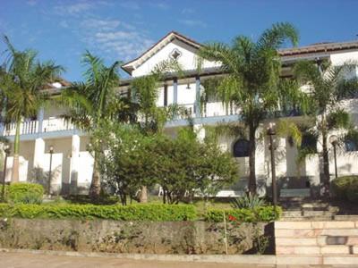 una gran casa blanca con palmeras delante en Hotel Providencia, en Mariana