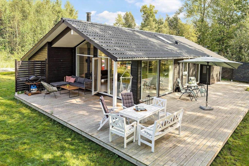 ein Haus mit einer Terrasse mit einem Tisch und Stühlen in der Unterkunft 6757 Hasle - Skovtoften 16 in Hasle
