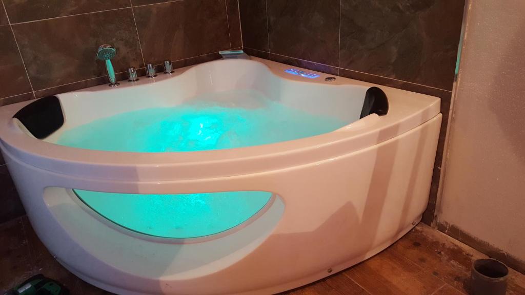 a bath tub with blue water in a bathroom at Apartamento del Abuelo in Isla