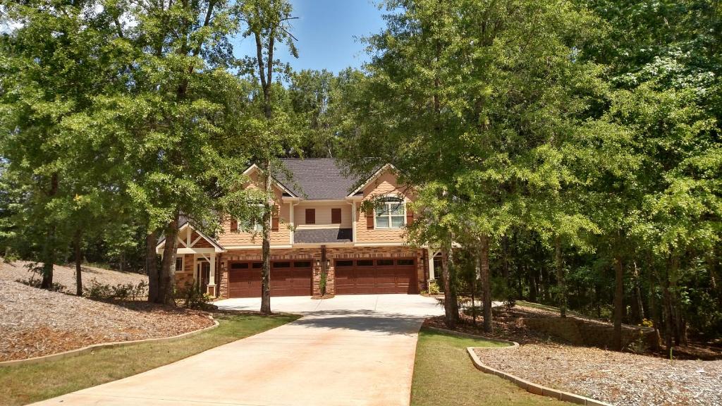 a house with a driveway and trees at Peachtree TownHome in Peachtree City