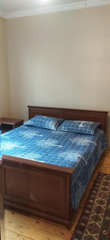 a bedroom with a bed with a blue comforter at Gabala,yard, house in Gabala