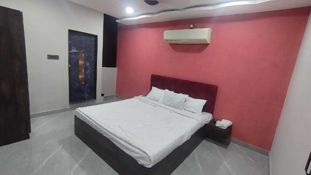 a bedroom with a red wall with a bed at HOTEL O SKY in Phundardih