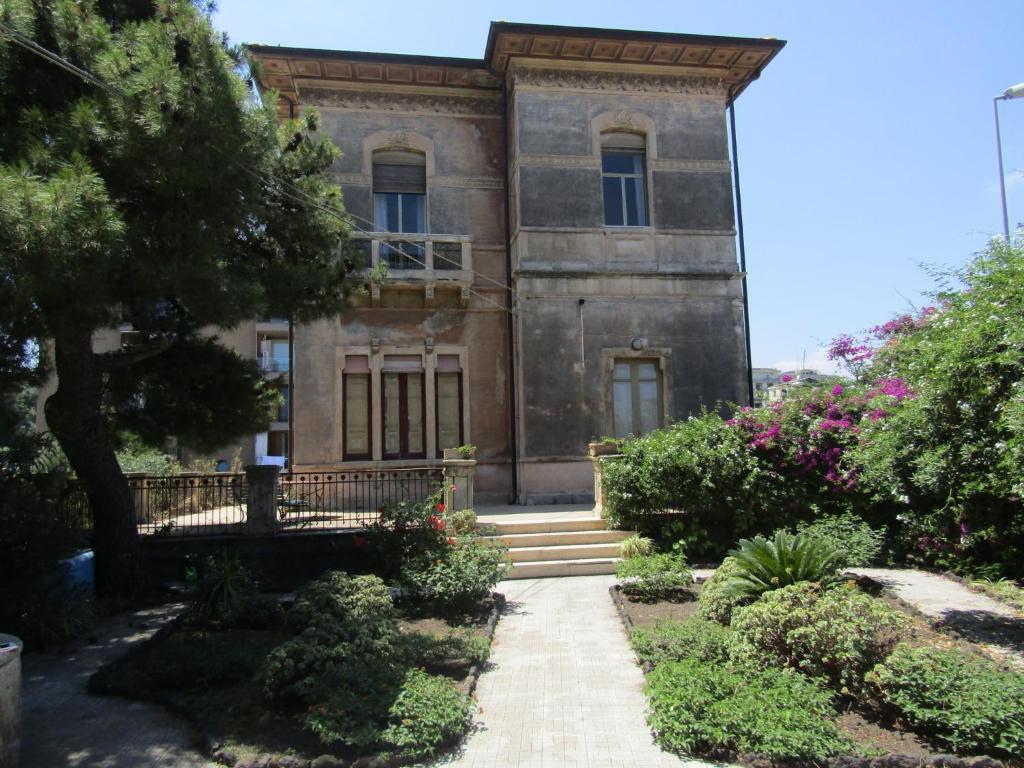 an old house with a garden in front of it at Villa Liberty in Catania