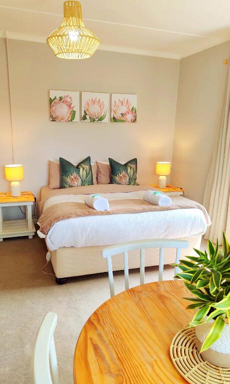 a bedroom with a bed and a table at Willowlea Cottage in Underberg