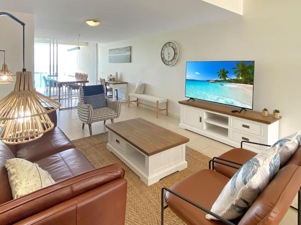 a living room with a couch and a flat screen tv at 1 Bright Point Apartment 4305 in Nelly Bay