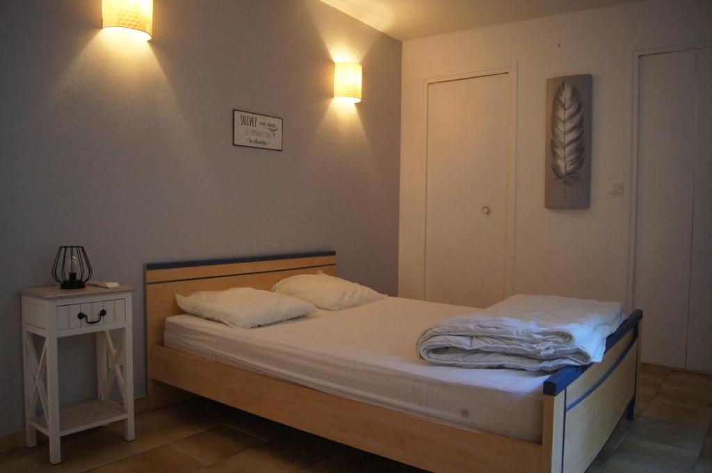 a small bedroom with a bed and a night stand at centre historique T2 RDC in La Roche-Posay