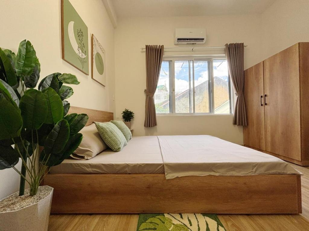 a bedroom with a bed and a potted plant at Central room in district 1, 450m to Ben Thanh market in Kon Rung (1)