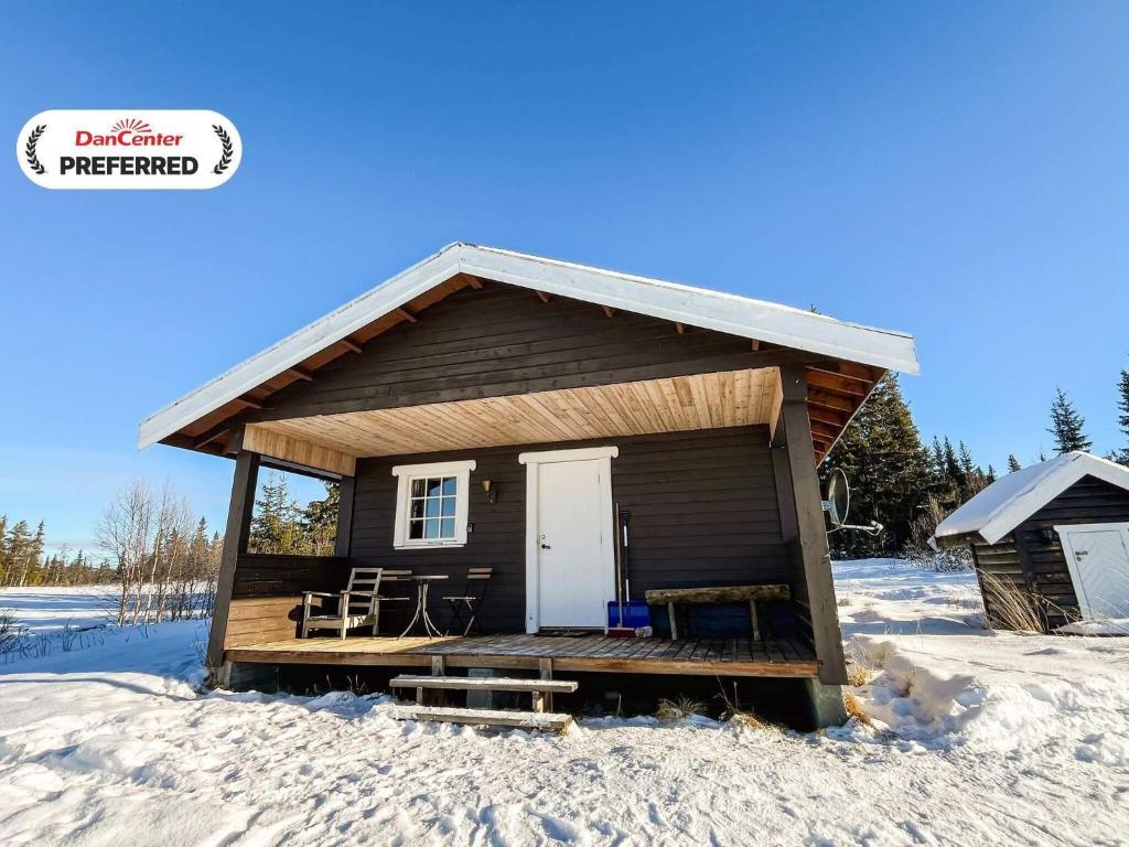a small cabin with a porch in the snow at 4 person holiday home in gol in Gol
