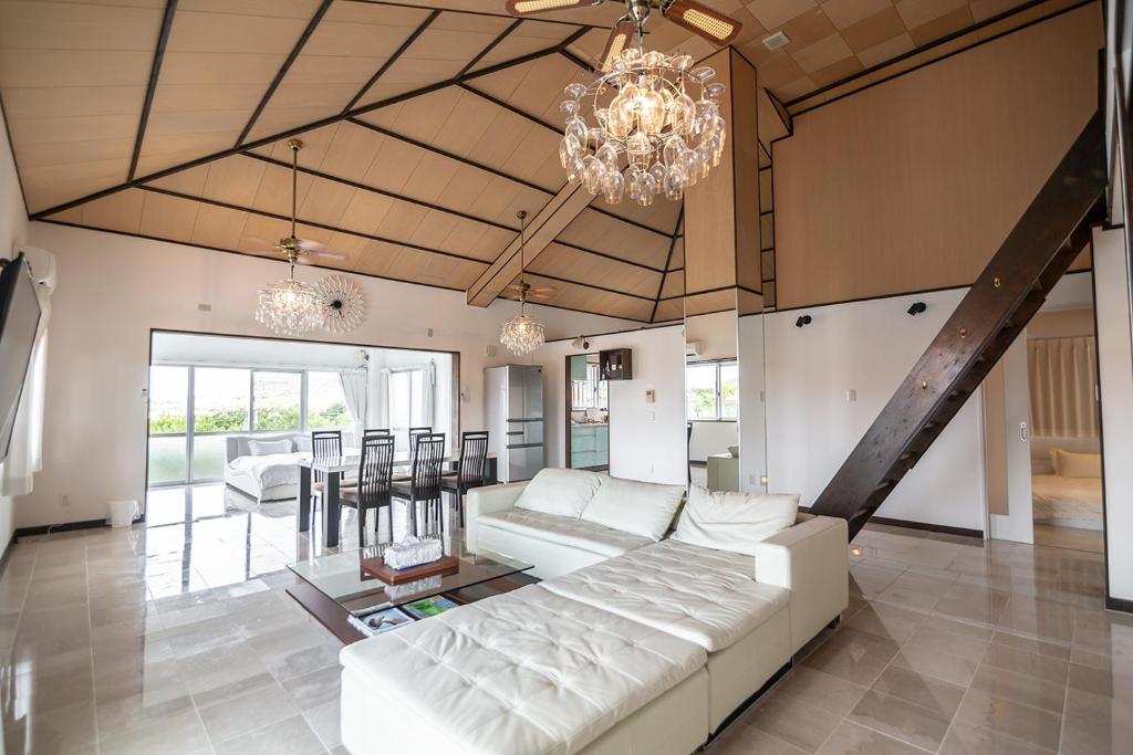 sala de estar con sofá blanco y lámpara de araña en Sommelier Villa ISHIGAKI, en Ishigaki Island