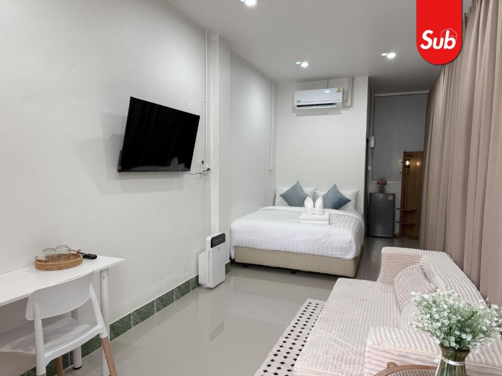 a small white bedroom with a bed and a desk at Happy One-Bedroom Stay in Hat Yai in Ban Thung Ngai