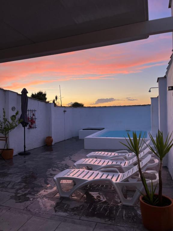 a patio with a view of a pool and sunset at La Casilla in Montilla