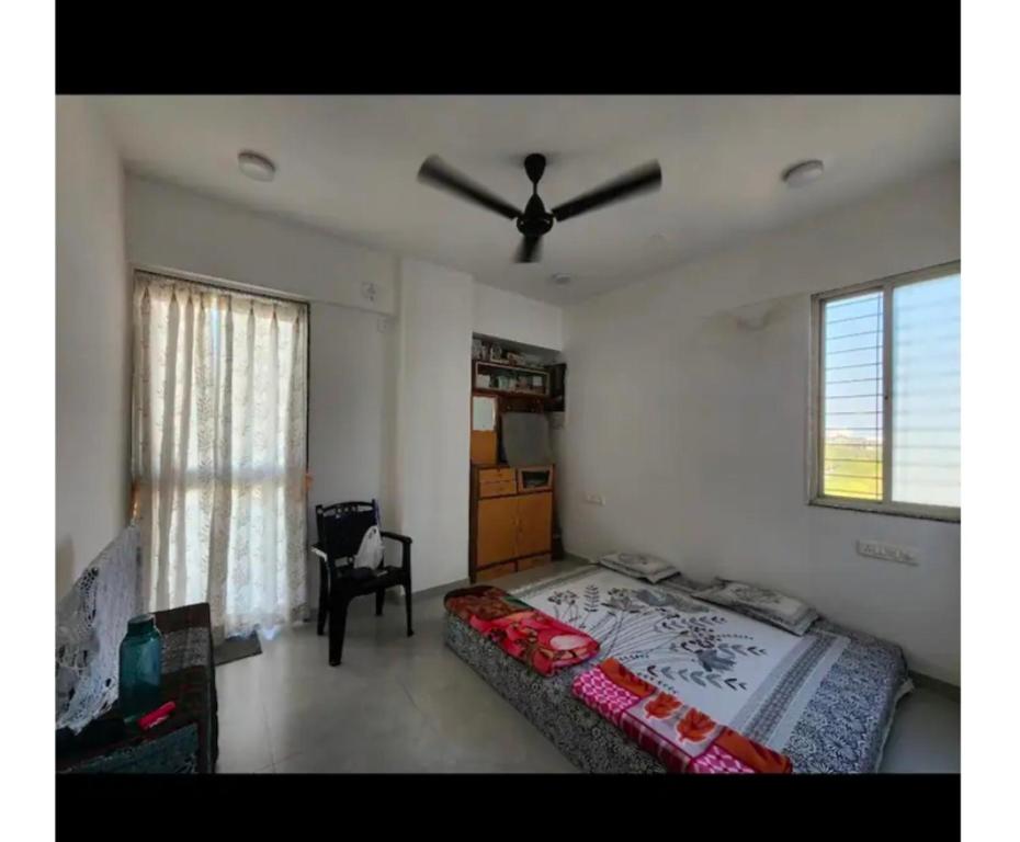 a bedroom with a bed and a ceiling fan at HarshYog Homestay in Nashik
