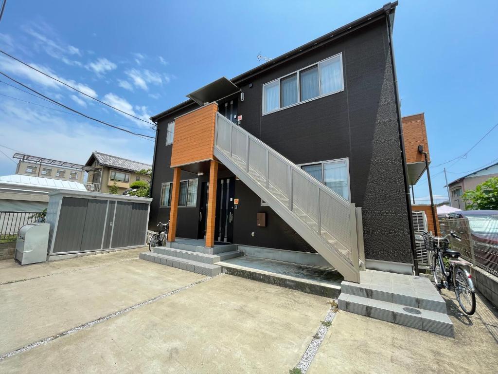 a black house with a staircase on the side of it at Yasuragi-KAWAGOE 1F in Kawagoe