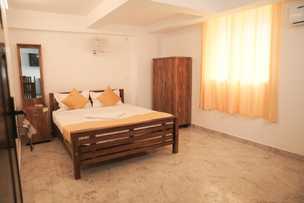 Un dormitorio con una cama y una ventana en Rajdhani Hospitality, en Kazhakuttam