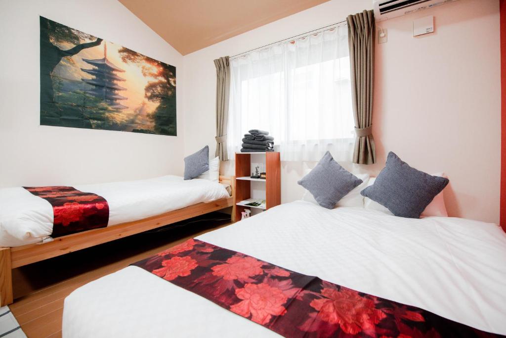 een slaapkamer met twee bedden en een raam bij Noir Toji Inn in Kyoto