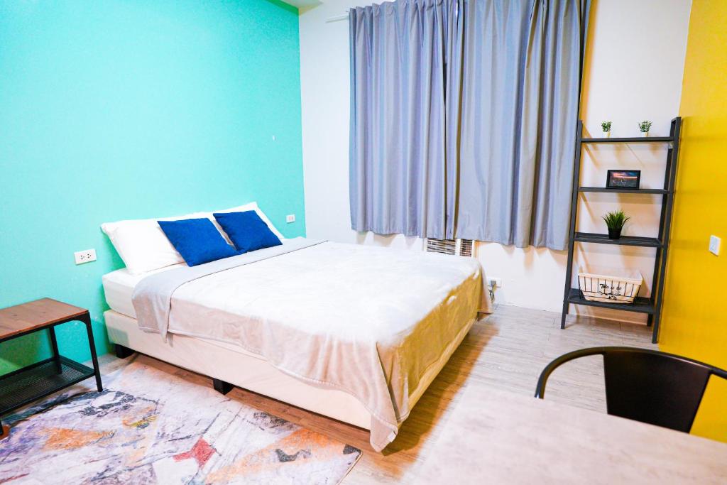 a bedroom with a large bed with blue walls at The City Flats Sacred Heart in Manila