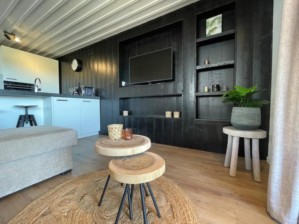 a living room with two tables and a kitchen at De Tuinkamer in Egmond aan den Hoef