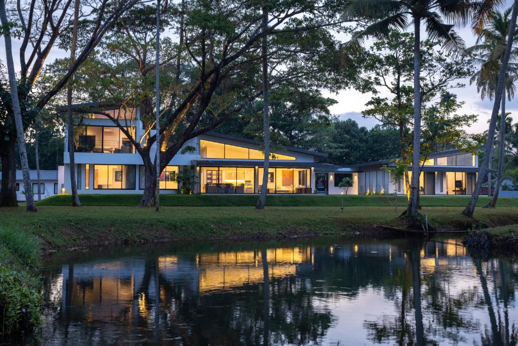 a house with a pond in front of it at Kazuri in Alleppey