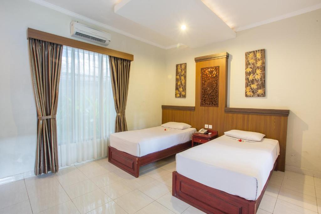 Postel nebo postele na pokoji v ubytování Hotel Sinar Bali Legian