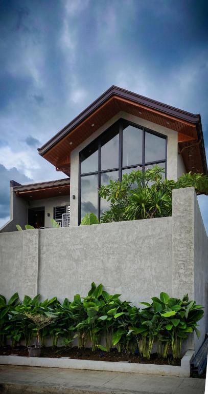a house with glass windows and a concrete fence at Villa Arcadia in Los Baños