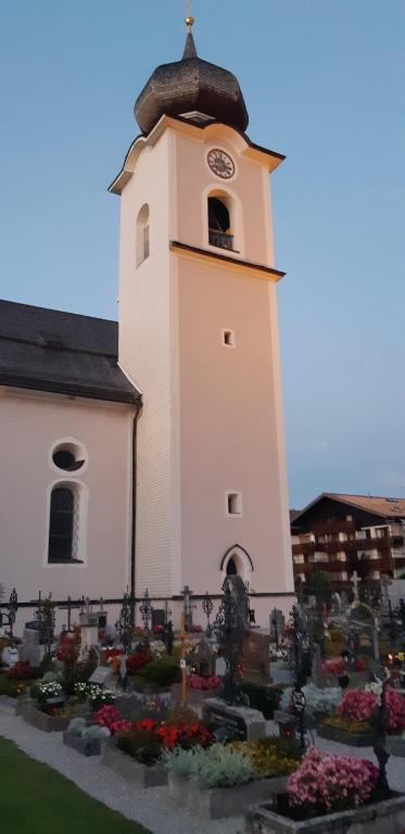 a church with a clock tower in a cemetery at Abis Ferienwohnung Salzkammergut in Strobl