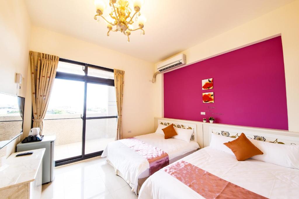吉安的住宿－自立民宿，配有两张床的带粉红色墙壁的客房