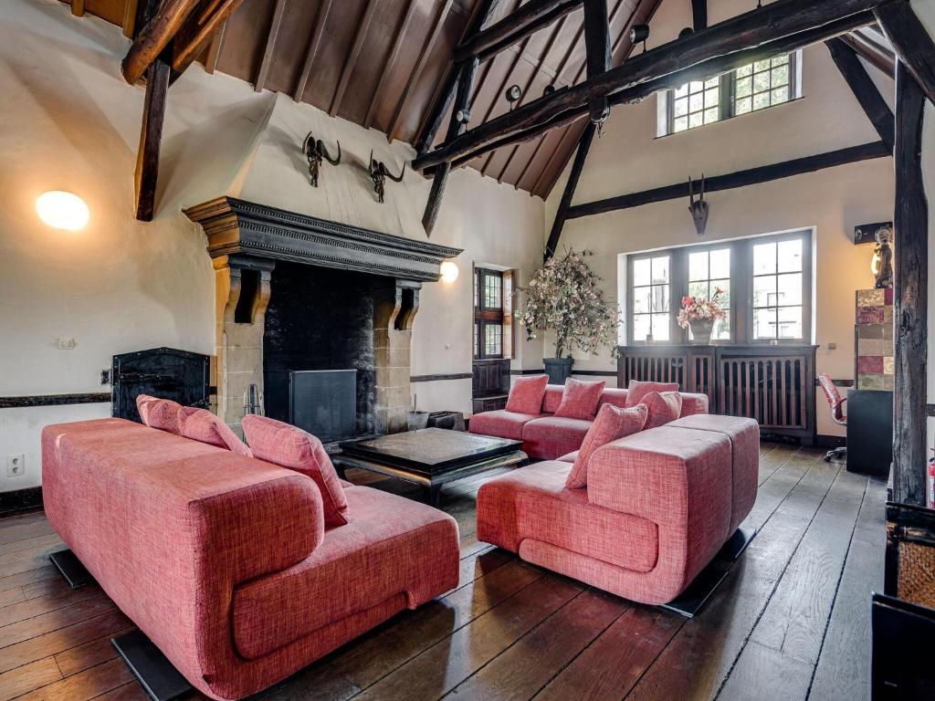 a living room with red furniture and a fireplace at Group Stay with Spa in Vielsalm in Vielsalm