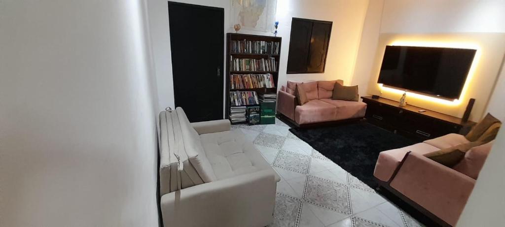 a living room with couches and a flat screen tv at Casa há 300m do PARQUE DA CIDADE - COP 30 in Belém