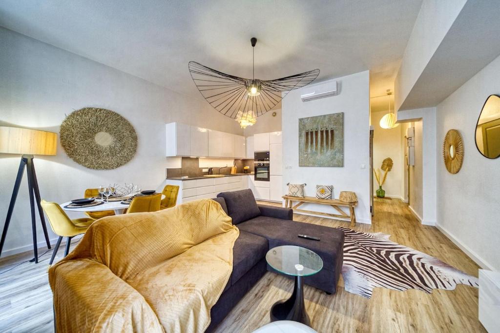 a living room with a couch and a table at R'Apparts Le Central Park in Grenoble