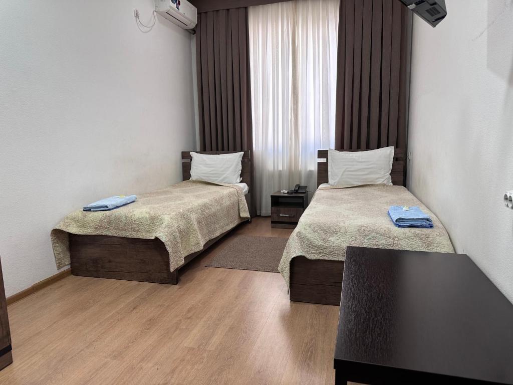 a hotel room with two beds and a table at A-Hotel Ex Magistral in Solnechnyy