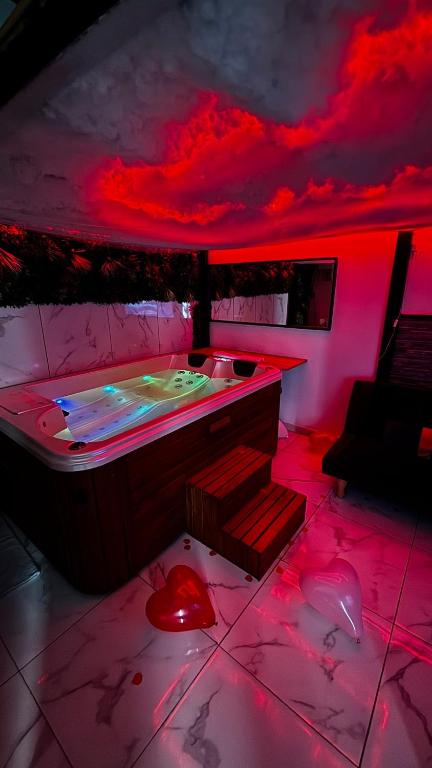 a room with a hot tub with red lighting at Appartement jacuzzi - Love Room in Lyon