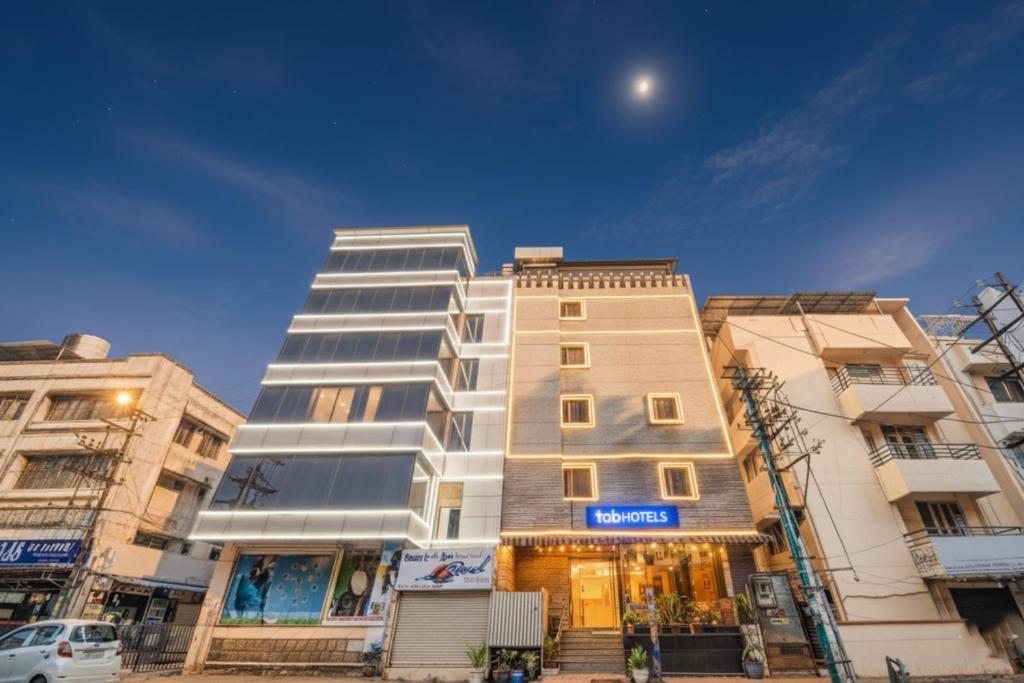 Un edificio alto y blanco frente a algunos edificios. en Via Sri Krishna Suites, en Bangalore