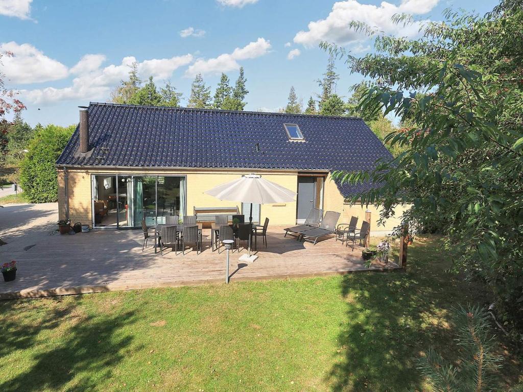 a house with a patio with chairs and an umbrella at 10 person holiday home in Væggerløse-By Traum in Marielyst