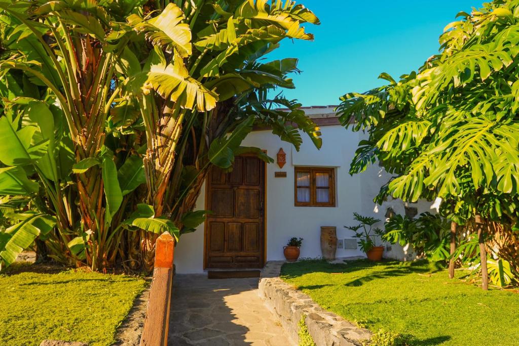 una casa con una porta in legno in un giardino di La Paredita Casa Acentejo a Tanque