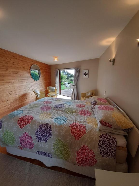 una camera da letto con un letto grande e una finestra di Abel Tasman Kaiteriteri Garden & Sea View Apartment a Kaiteriteri