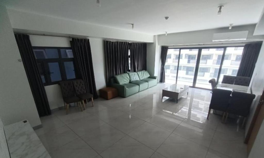 Sampongにある1 Bedroom Quirino Ave Paranaqueのリビングルーム(緑のソファ、椅子付)