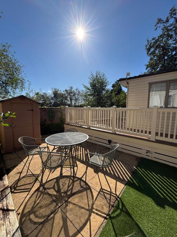 een terras met een tafel, stoelen en een hek bij 167 Ashburton in Longridge