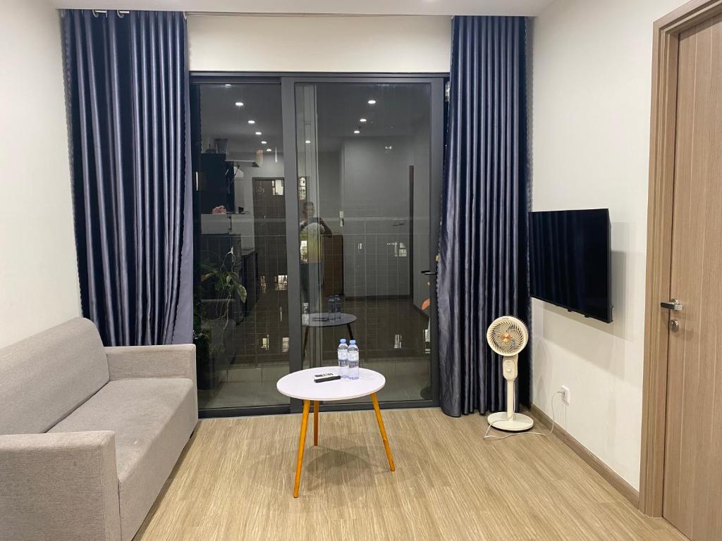 Phú ThúにあるThe Sakura - SA2 Vinhomes Smart Cityのソファとテーブルのあるリビングルーム