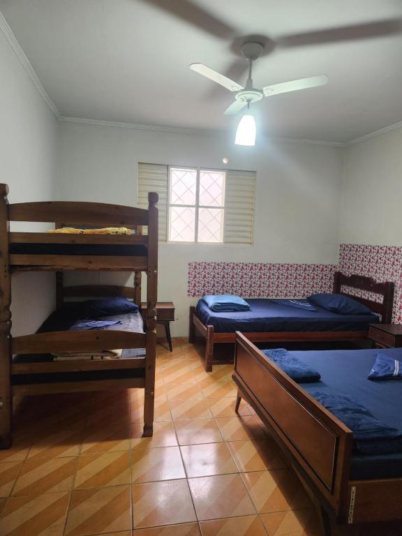 a room with three bunk beds and a ceiling fan at Casa tamanho Família Aconchegante in Bauru