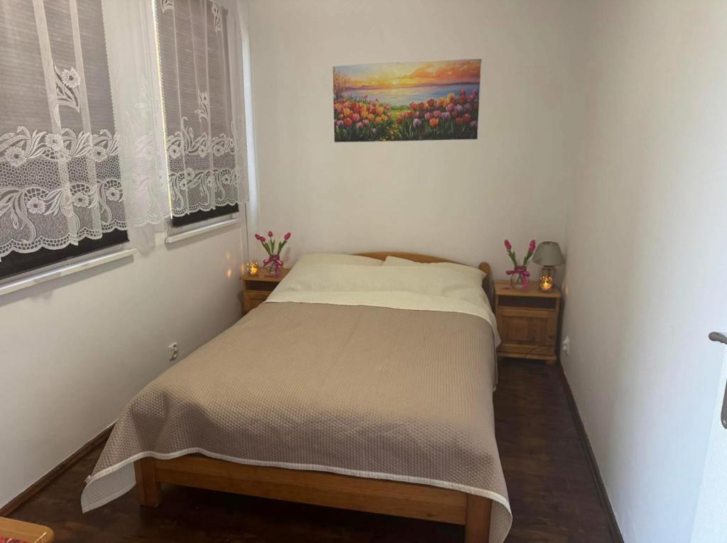 a small bed in a bedroom with a painting on the wall at DOMEK NR 5 z dwiema sypialniami in Tleń
