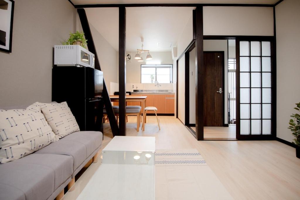 a living room with a couch and a table at GUAGUA house in Kyoto