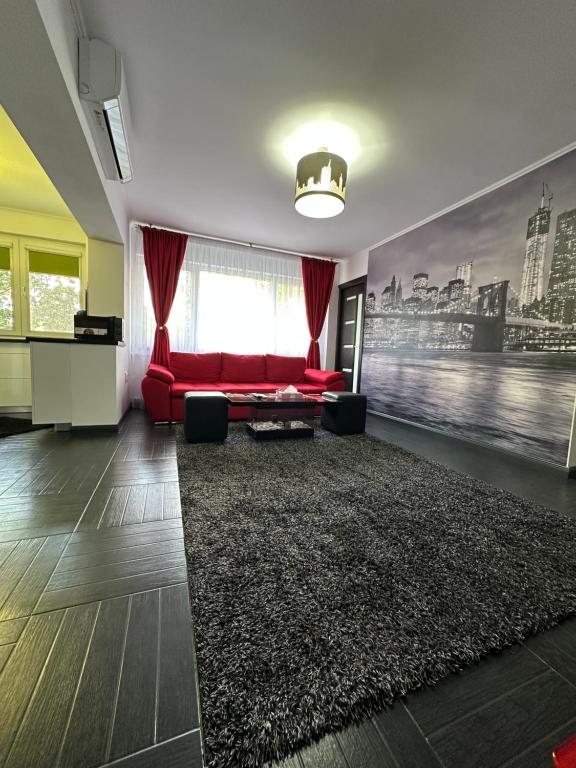 a living room with a red couch and a rug at Apartament 2 camere in Bucharest
