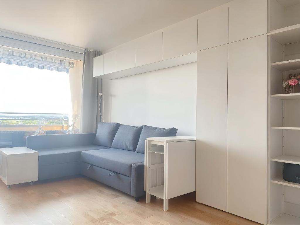 a living room with a blue couch and a window at Kerzen Boutique in Bad Salzuflen