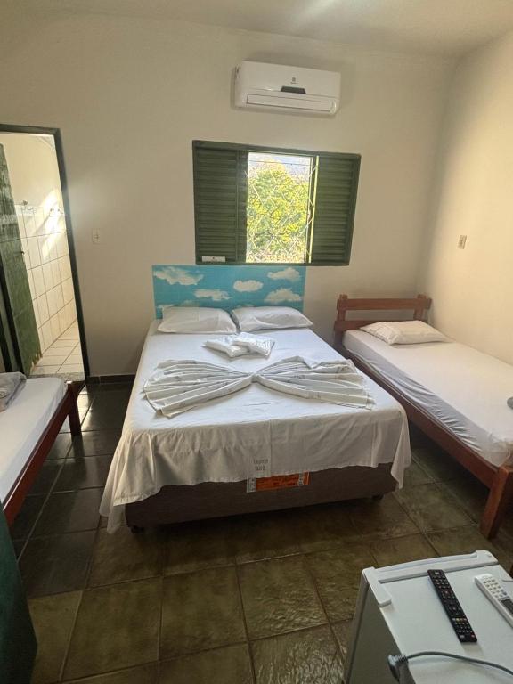 a bedroom with two beds and a window at Hotel Araguaia in Goiás