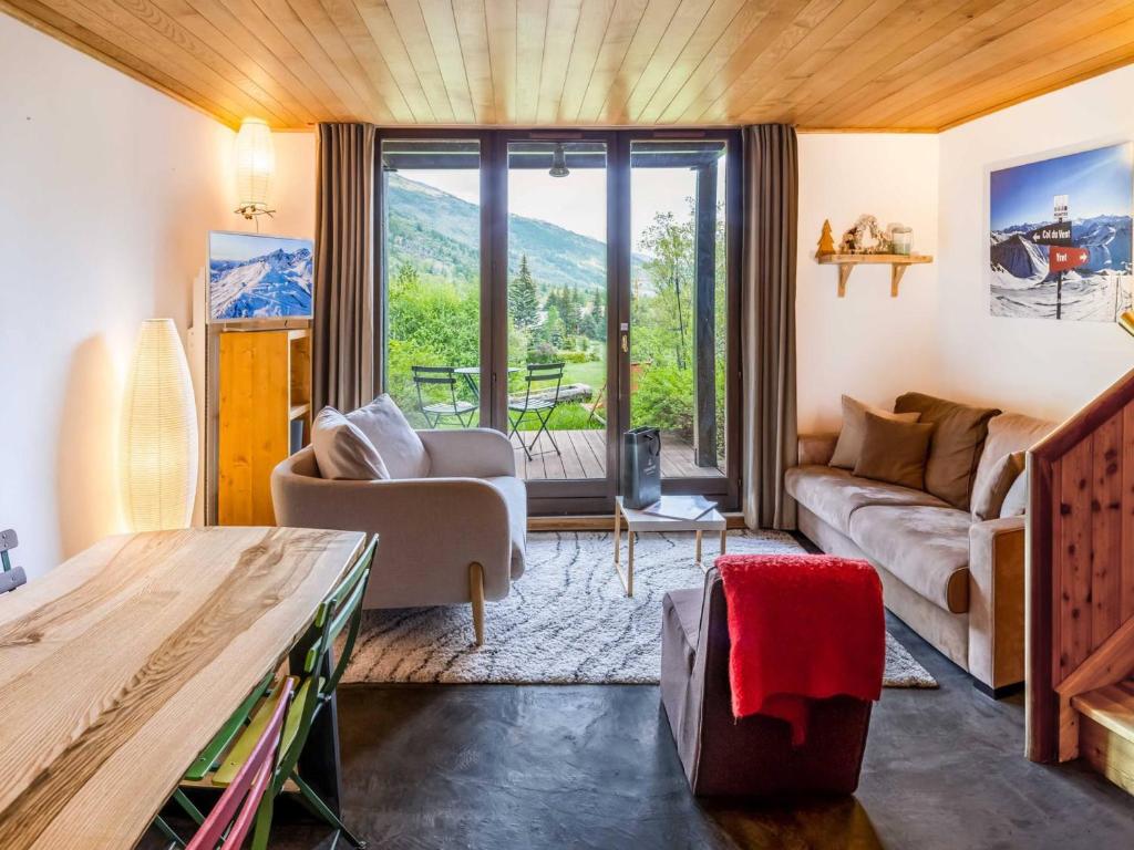a living room with a couch and a table at Duplex avec jardin et parking privatif à Serre Chevalier - FR-1-808-17 in Le Monêtier-les-Bains